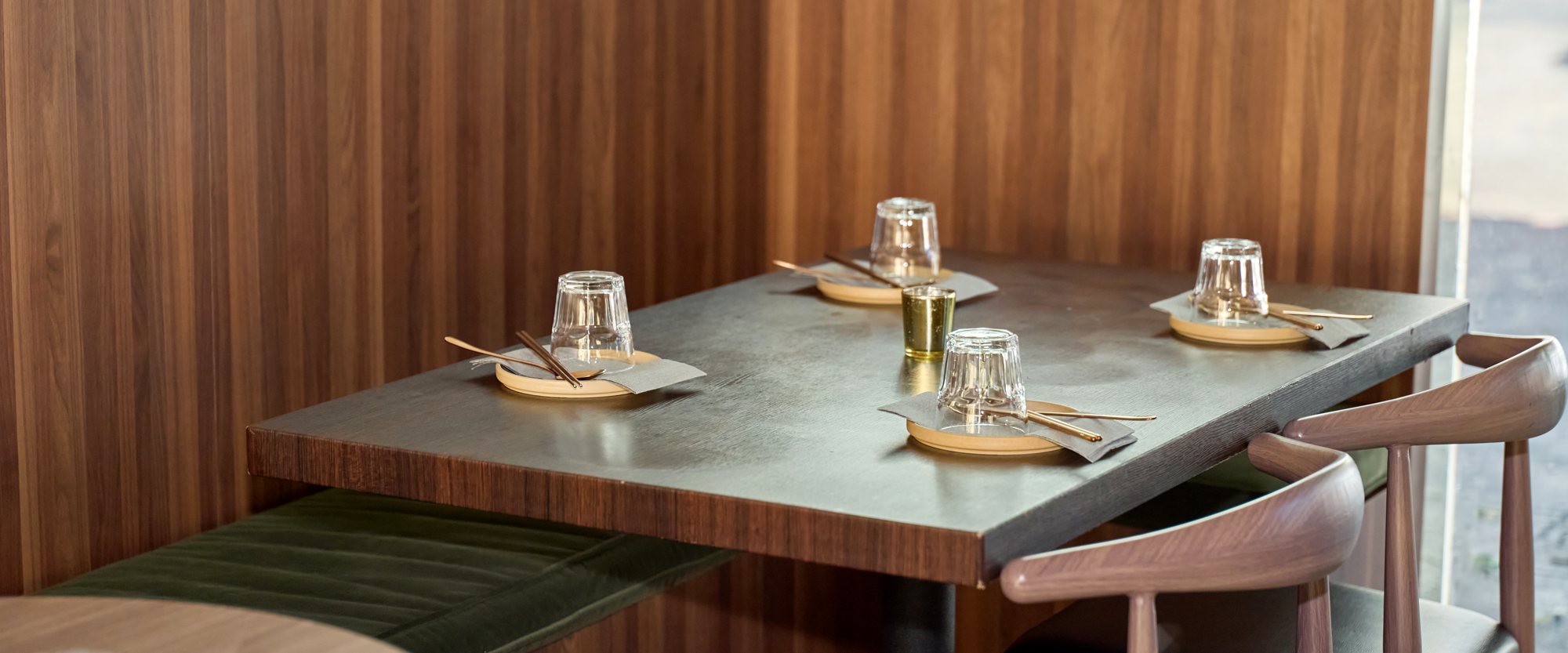 A walnut booth at Danbi under warm light