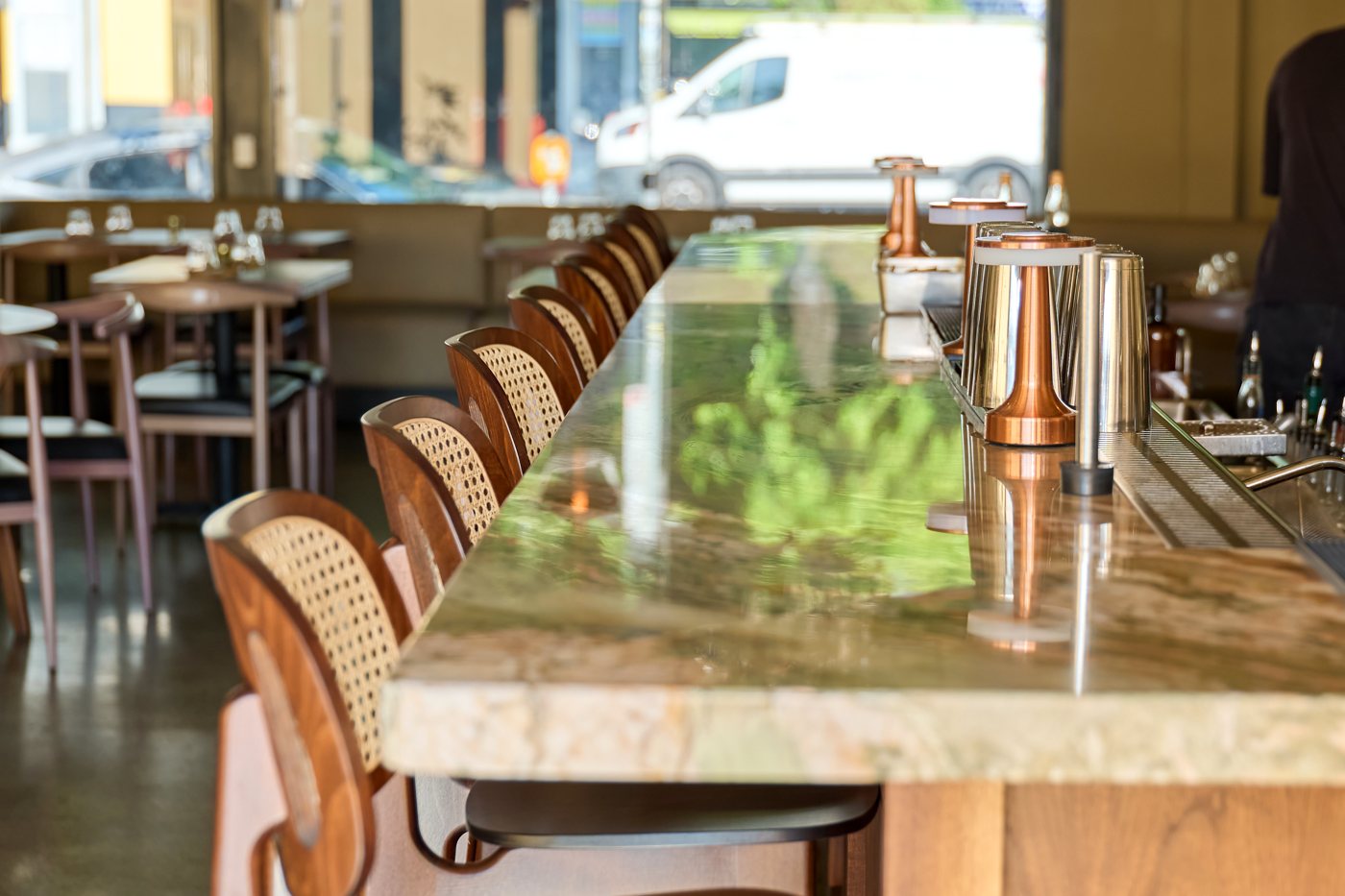 The marble bar at Danbi with cane stools and copper shakers